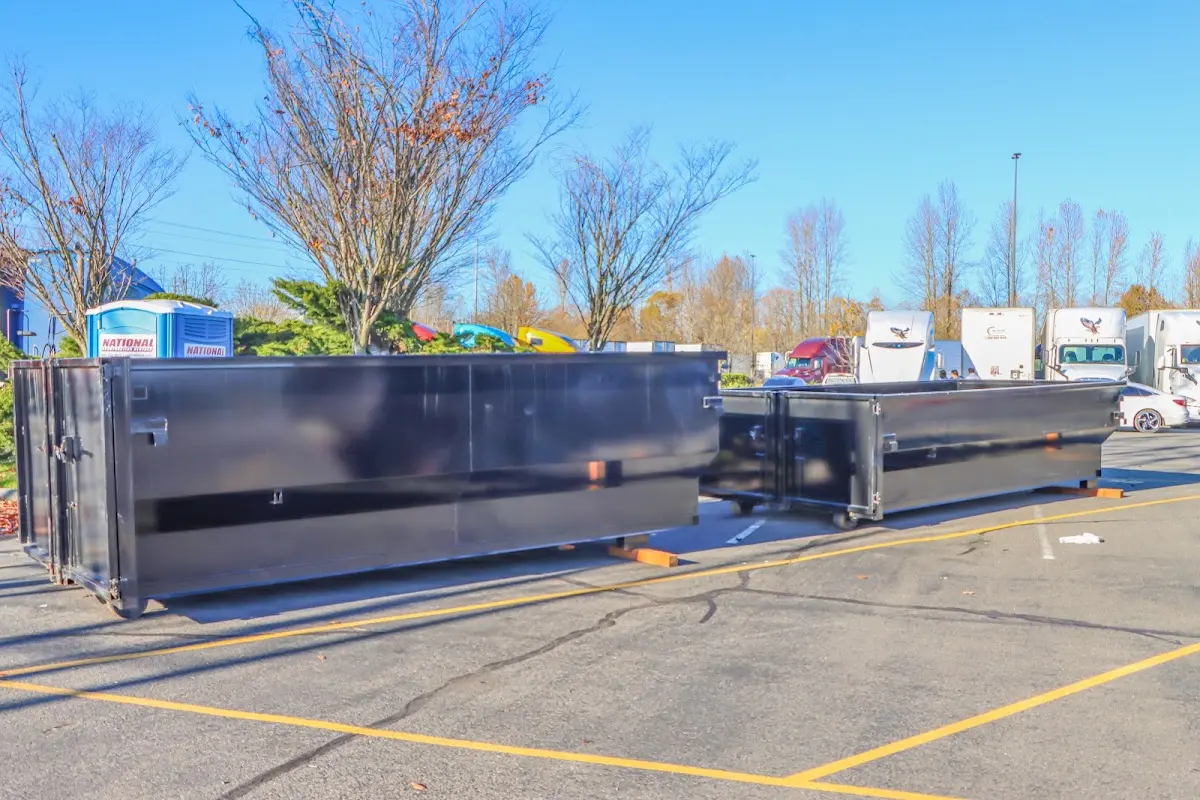 Professional dumpster rental service with roll-off container on residential driveway in Rigby